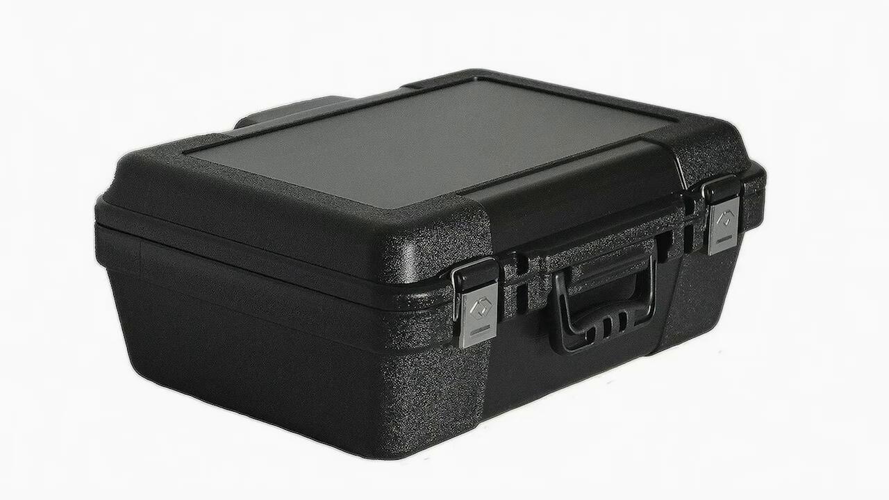 Maletín rígido de plástico negro con cierres metálicos sobre fondo blanco, del aviso para The Plastic Forming Company